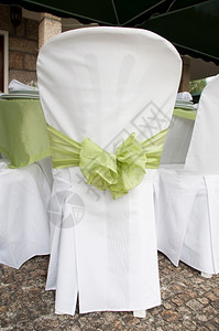 餐具白色的华丽婚礼椅子装饰在户外用绿丝带装饰银器图片