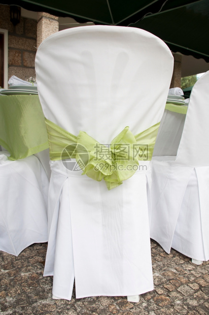 餐具白色的华丽婚礼椅子装饰在户外用绿丝带装饰银器图片