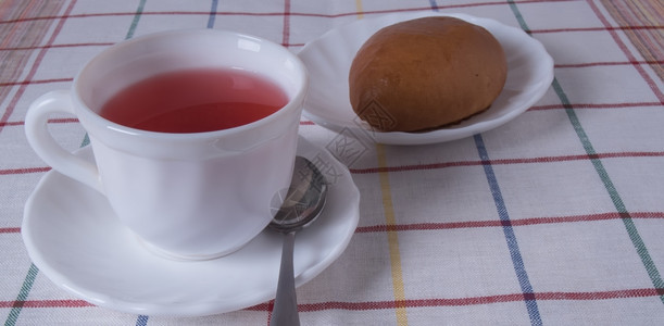 抗氧化剂常设站在桌上的白杯喝着水果茶和一盘白杯馅饼子里有水果茶和蛋糕草本图片