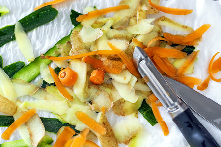 环境的吃脱皮蔬菜胡萝卜马铃薯和苏奇尼的植物皮用剥机重新开食物和健康生活方式的概念图片