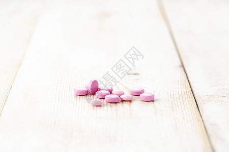 粉红圆药丸近身木桌本底健康药剂关心图片