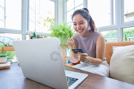 居家购物的年轻女孩微笑高清图片素材