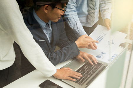 研究团队工作进程商企讨论人营销计划会议与办公笔记本电脑和财务文件数据一起放在桌面上的概念统计手图片