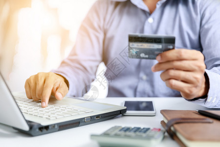 笔记本电脑金融话商人用信卡进行网上购物的生意人图片