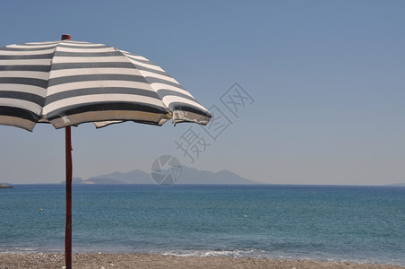 天空热带希腊Kefalos海滩高斯带希腊雨伞的美丽海滩场景天堂图片