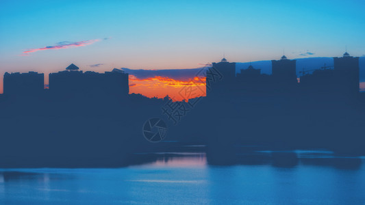 建筑学户外夜景背高升起的建筑与日落对比的轮廓反映于湖中黑夜日落城市背景中心背景图片