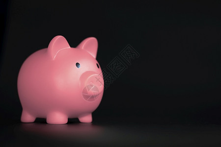 粉色的节省简单黑色背景上水平的粉色小猪银行带有复制空间商业储蓄和金融概念阴影黑色背景上水平的粉色小猪银行带有复制空间储蓄和金融概图片