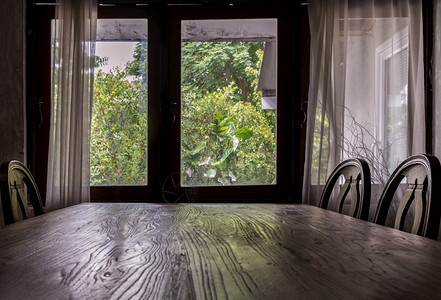 具体来说吃餐厅的木制桌和椅子传统房屋中的木制窗和白帘无焦点特别是座位图片