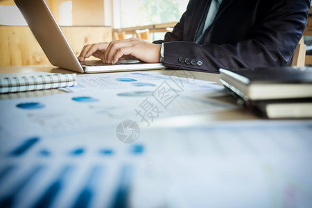 在办公室的年轻商业经理桌上有笔记本电脑和财务数据文件业务经理男会议团队图片