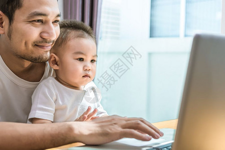 单身父亲和儿子一起使用可喜的笔记本电脑科技与生活方式概念快乐家庭与婴儿主题成人童年母图片