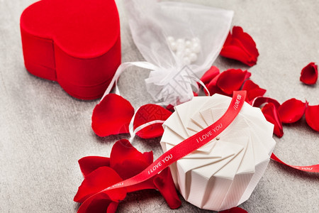 假期赠品盒红玫瑰和花瓣在木制桌子上的照片婚姻有创造力的图片