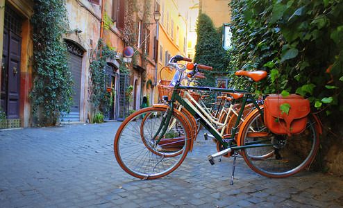 老的旅行城市骑自车站在罗马老街的商店前图片