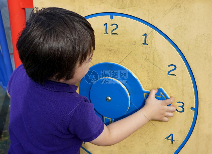 儿童学习时间夏季在游戏场用木钟打球幼童学会讲时间小手通过玩耍促进儿童成长的学习概念幼儿男孩学会讲时间儿童掌握技巧手表为了分钟图片