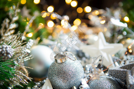 庆典木制的圣诞背景美丽的散结婚戒指躺在圣诞球上背景结婚戒指放在圣诞球上问候图片