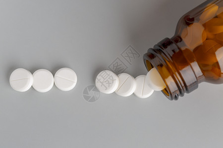 一瓶棕色玻璃药丸和白一瓶棕玻璃药丸和白圆形疾病用图片