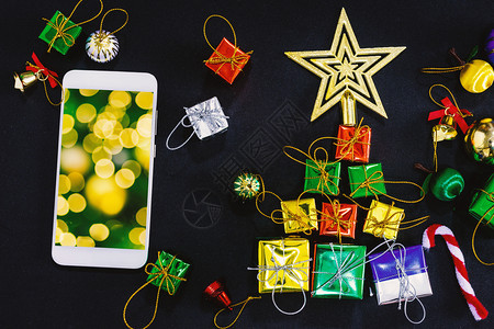 丝带星以空智能手机笔记本和铅制作的圣诞节庆装饰最佳图像黑纸背景新年概念黄光闪亮摘要圆环沟通图片