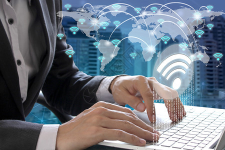 技术蓝色的商人手在世界使用带有wifi图标连接和网络通信的笔记本电脑互联网图片