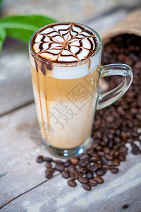 黑色的饮料上顶有巧克力糖浆艺术的热拿铁马奇亚托咖啡木质桌背景咖啡因图片