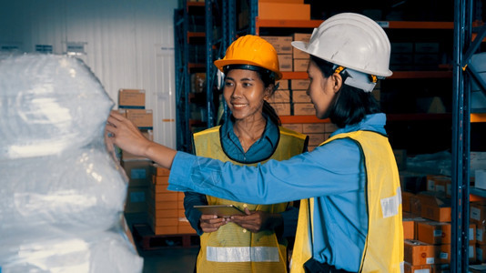 货运在仓库工作的女人物流供应链和仓库业务概念在仓库工作的女人托盘纸板图片