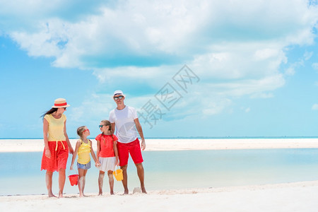 父母和孩子在海滩上的在度假年轻家庭玩得开心极了阳光热带孩子们图片