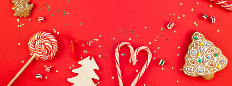 新年或圣诞装饰公寓铺着最顶端的视野Xmas节庆祝手工制作装饰木玩具甜金星在红纸背景上闪亮相发光的宽甘蔗图片
