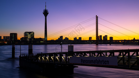 黄昏户外部的莱茵河上多姿彩的日落在德国Dusseldorf市风景中图片