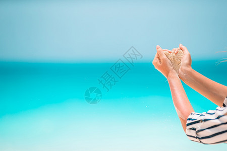 保持女人手握白色热带海滩形心女人手握白色热带海滩形心手工制作的闲暇图片