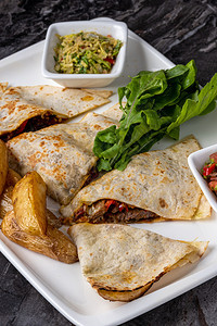 一顿饭克萨迪亚斯番茄墨西哥玉米饼和大理石桌上的肉沙拉和胡椒墨西哥美味的饼干图片
