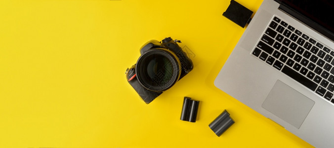 工作配件远程摄影师用设备平躺构图黄色背景上的摄影师用设备和笔记本电脑黄色背景上的摄影师办公场所复制空间图片