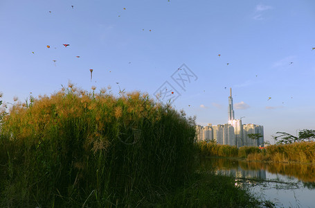 飞行场地越南胡志明市令人惊异的景色晚上越南胡志明市地貌奇异许多风筝在日落天空上飞翔高楼建筑对河流水的反射惊人图片