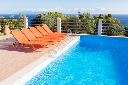 游泳池休息的橙色躺椅图片