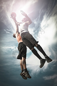 男生空气两个篮球运动员在街头打篮子一起跳来接球去追图片
