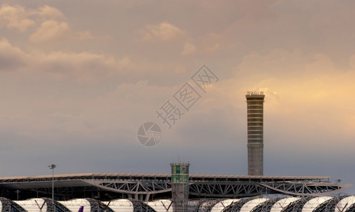 地面经过机场交通控制塔的机场屋顶和空中交通管制塔台用雷达航空技术控制气间机场大楼使用日落天空和白云机场楼面有日落天和白云外部的图片