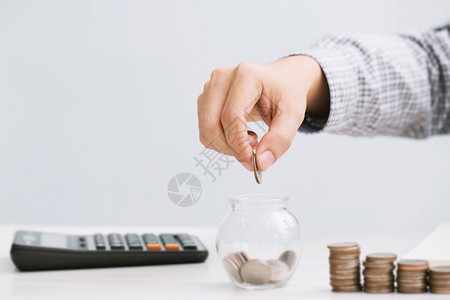 支付计算器将硬币放进玻璃瓶的手架概念中WrideFinance会计核算公司WorkingEccountryDescription图片