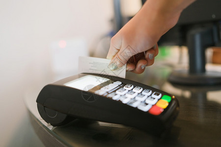 关于Caucasian女手持借记卡或信用的近视侧边图她们用终端付款机在商店支帐单消费主义销售债务图片