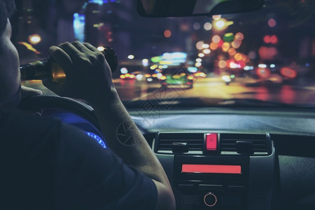违反人晚上在城里开车时喝啤酒左手驾驶系统很危险左手驾驶系统人们危险的图片
