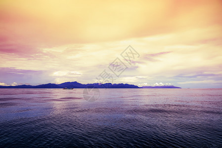 当地客船正在海面水上航行在泰国PakBara湾日落泰国Satun海PakBara湾日落时清亮天空下以明红黄天为背景用环绕着岛屿的图片