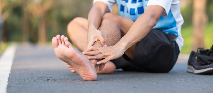 夏天在训练亚裔运动员在上午和健康概念外跑步和锻炼后脚踝疼痛和问题时手持运动腿部受伤肌肉痛苦的年轻健身男子在训练亚裔跑者他的事故图片