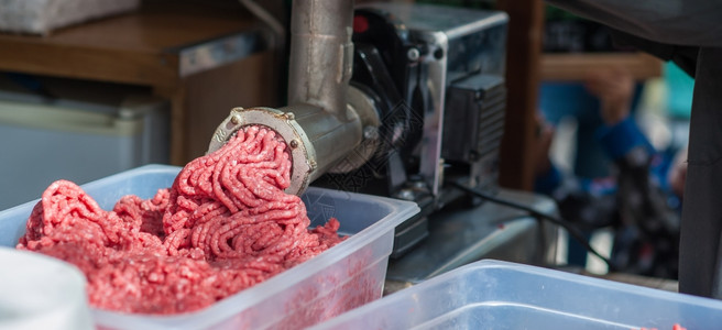 切割屠宰场新鲜肉机的托盘将放回机器里工业的图片