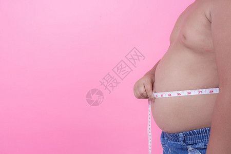 失去在粉红背景上体重超的肥胖男孩身体亚洲人图片