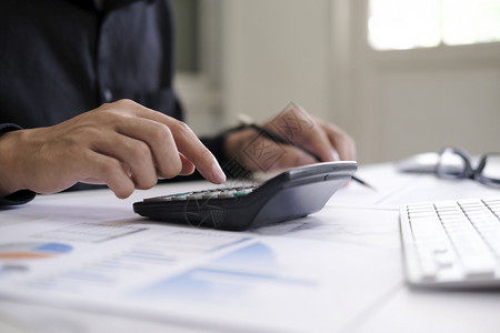 商业会计概念使用算机膝上型电脑预算和办公室借纸计算器的商行员数据贷款商人图片