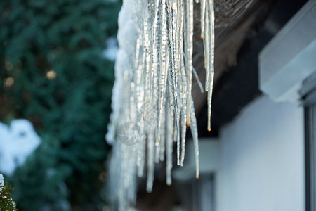 户外冰柱从雪花屋顶上挂下来水闪光图片