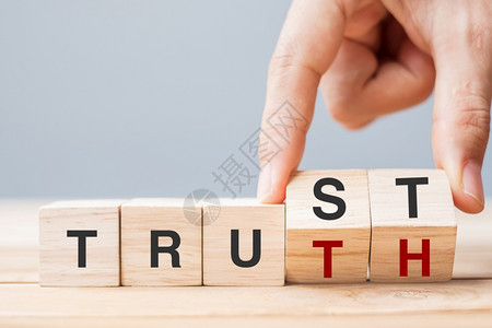 希望风险可靠商人用手来改变木制立方块将信任和真理的商业文字放在桌上的背景可信赖仰和诚实概念背景图片