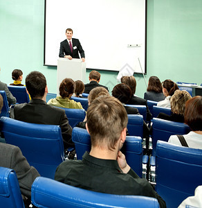 按成功的商人在业会议上与听众交谈在商业会议中投影观众图片
