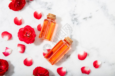 滴管自然玻璃瓶和有花瓣的小红玫瑰香水中含有腐烂的玫瑰水闻图片