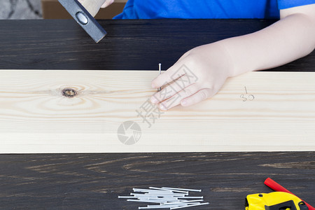 装修建筑类的一部分在工伤课期间儿童用锤钉子在木板上时理事会修统治者男子的手活动工具图片