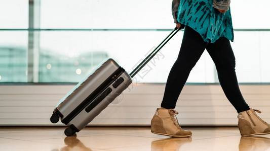 年轻的空气窗户旅行者携带李手提箱随走乘客在机场候站乘坐飞出行的旅客图片