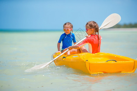 血管乘坐黄色皮划艇在海中的可爱小女孩享受黄色皮划艇的可爱女孩安详水图片
