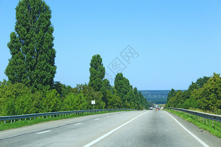 划分高速公路Asphalt路两边有带树木和灌的分隔条旅行目的地程Askalt概念道路两边有带树和灌木的分隔条驾驶图片