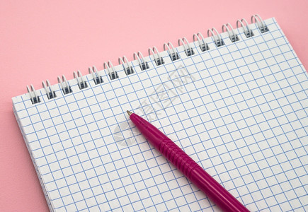 最小的笔记一张空白格子纸记事本和粉红色的笔空白图片